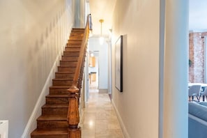 Main Floor Hallway leading to the Kitchen and Living and Dining Room. Original to the home are the walnut staircase and railing, just stunning!