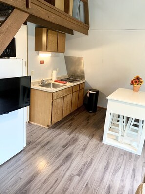Kitchenette with stove top, fridge, and microwave