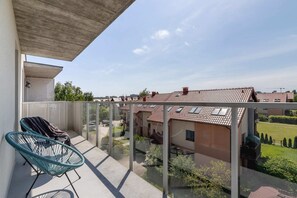 Furnished balcony with green surroundings. 