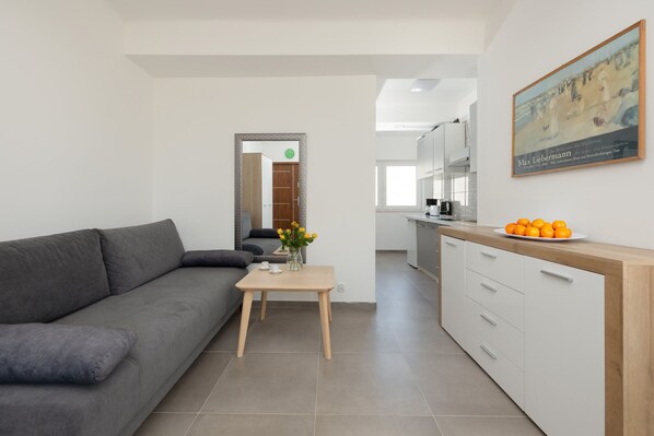A cozy living area with a modern sofa, minimal decor, and a soft color palette for relaxation.
