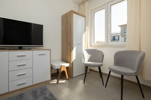 A modern seating area with chairs and a table, situated near a large window.