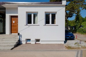 The front exterior of the house, showcasing a simple, clean design with a small outdoor area.
