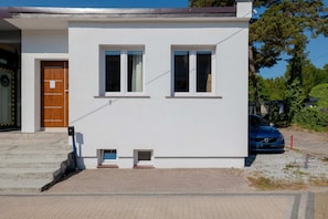The front exterior of the house, showcasing a simple, clean design with a small outdoor area.