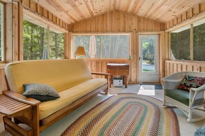 The screen porch offers a second gathering location for guest to enjoy the site and sounds of the surrounding woods