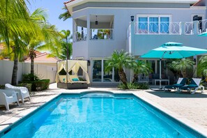 Glorious pool area of the villa in Aruba - Cosy beach chairs and neat and clean towels available - Beautiful views - Superbly designed pool area with umbrella shades - Refreshing Environment - Vibrant Atmosphere