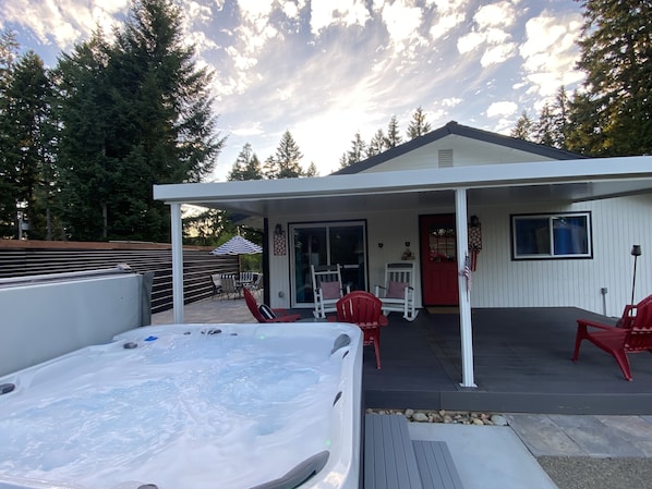 Hot tub is located off the covered back deck from the master or back door.