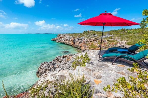 The sun loungers located by the guesthouse at South Seas can be shaded by the umbrella.