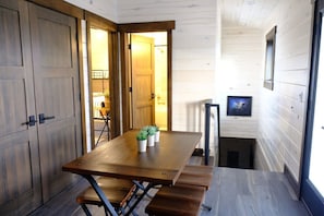 DINING TABLE WITH SEATING FOR FOUR, WASHER AND DRYER IN DOUBLE DOOR CLOSET.