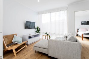 Living zone, complete with smart TV with master bedroom in background.