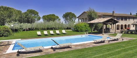 La Villa rodeada por el jardín bien cuidado y la bonita piscina