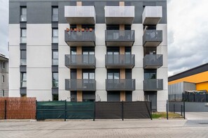 An exterior shot of the building, showcasing modern architectural design with balconies.
