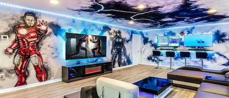 Marvel themed loft room with 3 large screen TVs and a bar seating area.