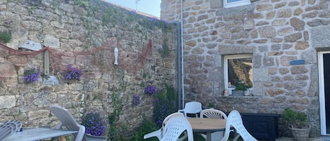 Entrée du gîte et son jardinet privé avec les campanules du printemps.