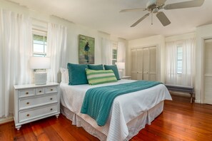 Primary bedroom with a king-size bed, crisp linens, and charming coastal touches. Natural light and soft decor create a relaxing retreat.