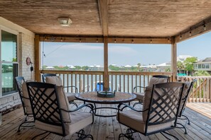 Sspacious covered porch, complete with comfortable outdoor seating and panoramic views of Dauphin Island's waterways