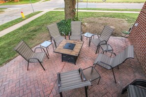 Shaded front brick patio with fire pit. Marshmallow sticks available in home too