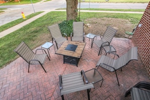 Shaded front brick patio with fire pit. Marshmallow sticks available in home too