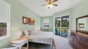 primary bedroom featuring king bed, workspace, and access to lanai