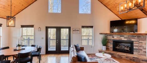 Open concept living and dining space for 7 with bar top seating right next to it in the kitchen.