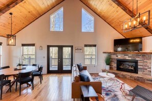 Open concept living and dining space for 7 with bar top seating right next to it in the kitchen.