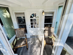 Front porch screened with rocking chairs