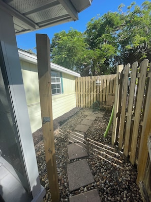 Fenced in side yard with outdoor shower and grill