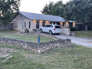 Hill country living in large stone home w/ welcoming dawn to dusk front lights.