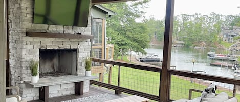 Covered back porch overlooking the pool and lake