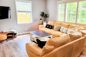 Large ROKU TV, leather sectional & ottomans provide plenty of seating. Perfectly situated right off the kitchen & dining space allows for large gatherings. Coffee table drawer has everything  for a family game of Pictionary - no paper needed!