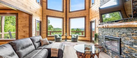 LIVING ROOM WITH STONE FIREPLACE OVERLOOKING THE BEAUTIFUL SMOKY MOUNTAINS