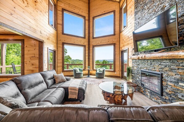 LIVING ROOM WITH STONE FIREPLACE OVERLOOKING THE BEAUTIFUL SMOKY MOUNTAINS