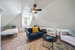 Two twin beds in the loft along with a second living space and tv area. 