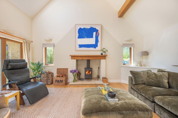 Beautiful double height sitting room with log burner.