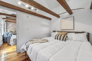 Large king sized bed with vaulted ceilings in the bedroom off the kitchen