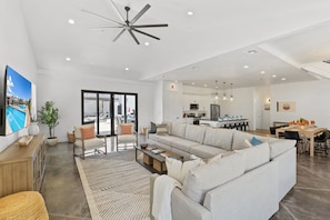 This spacious and beautifully designed living area features an oversized, cozy sectional, an open-concept kitchen, and ample seating for everyone—perfect for hosting and accommodating up to 20 guests in style and comfort.