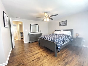 Spacious Master Bedroom with Queen bed, modern yet, cozy décor, and full closet with wood hangers.