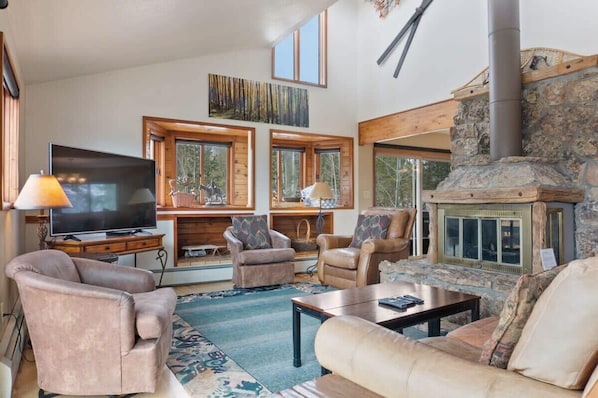 The cozy living room is the perfect spot to hang with loved ones as you warm up by the stone hearth fireplace and take in the surrounding views.