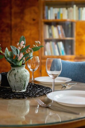 Close-up of dining table with tableware and decorative flower vase.