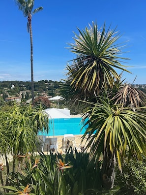 Vue sur le jardin et la piscine depuis l’entrée de la villa