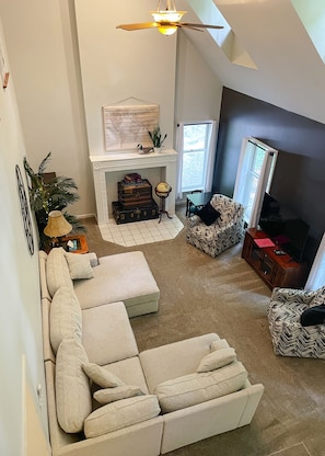 the living room with sectional couch, 2 swivel chairs, smart tv, dvd player