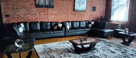 Spacious Ash Grey/Black Themed living room with huge CostaBrinker double chaise couch with seating for 9