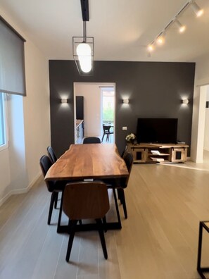 Living room with big-screen TV and a large dining table (sits up to 8 people)