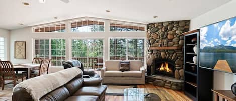 Relax and recharge in this light-filled home where you will find soaring windows and a spacious deck overlooking the surrounding trees.