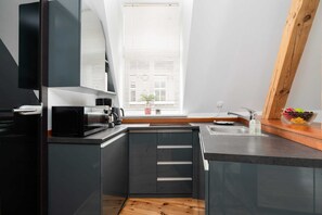 A modern kitchenette equipped with dark cabinets, a sink, and ample counter space, blending functionality with style.
