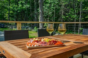 Expansive porch featuring a dining table and a BBQ setup, ideal for enjoying outdoor meals and hosting barbecues.