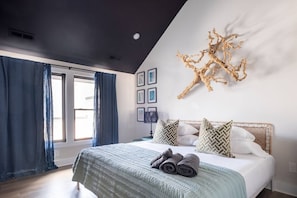 This top floor bedroom has a king size bed and ensuite bathroom with walk-in shower. Large flat screen TV. Easily accessible to rooftop deck, too! Overhead fan and blackout curtains.