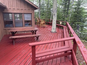 Deck with redwood picnic table and Adirondack chairs.
