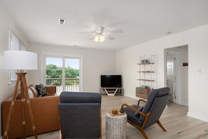 Living Room featuring smart TV, coffee table, sofa, two chairs and ceiling fan