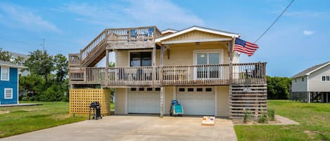 Front of House featuring corn hole and beach chart with four beach chairs