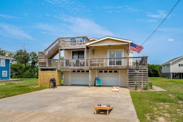 Front of House featuring corn hole and beach chart with four beach chairs